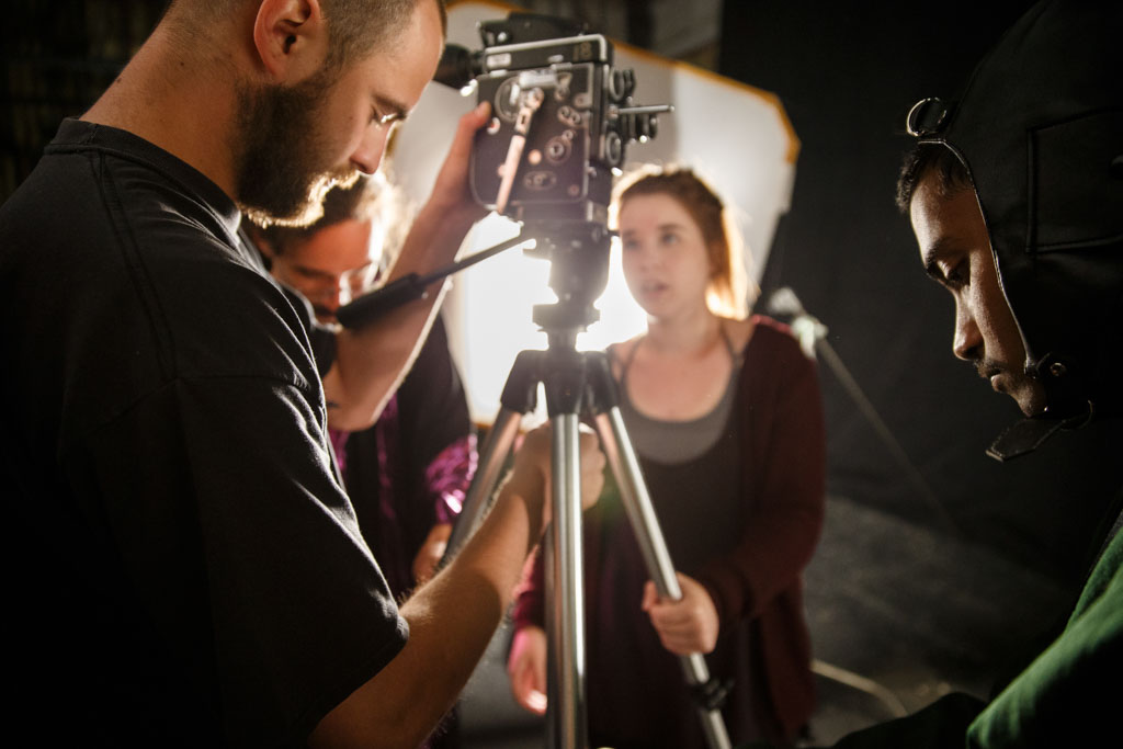 Studio set with students setting up camera and lighting