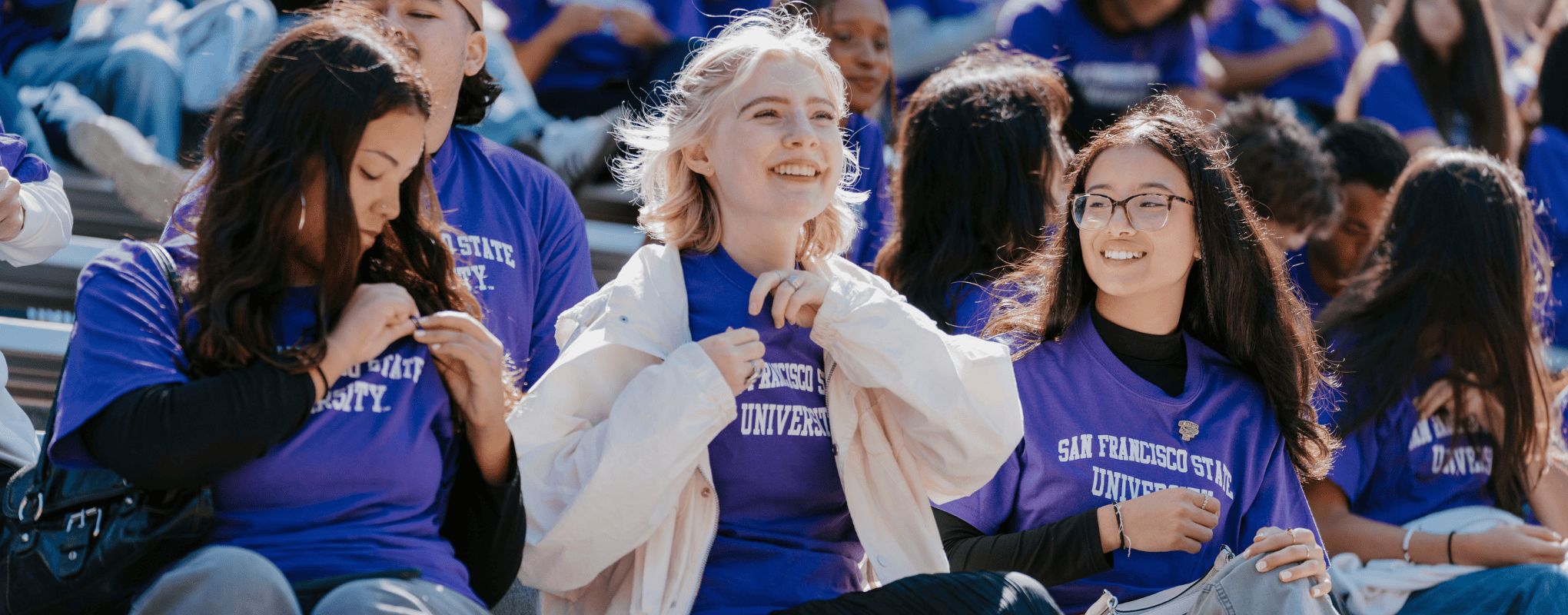 SF State student adding pin to shirt during Orientation Pinning Ceremony