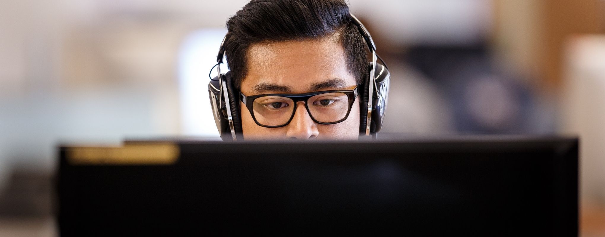 Student with headphones looking at computer