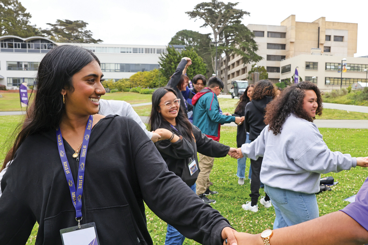 Smiling SF State students holding hands and playing a game