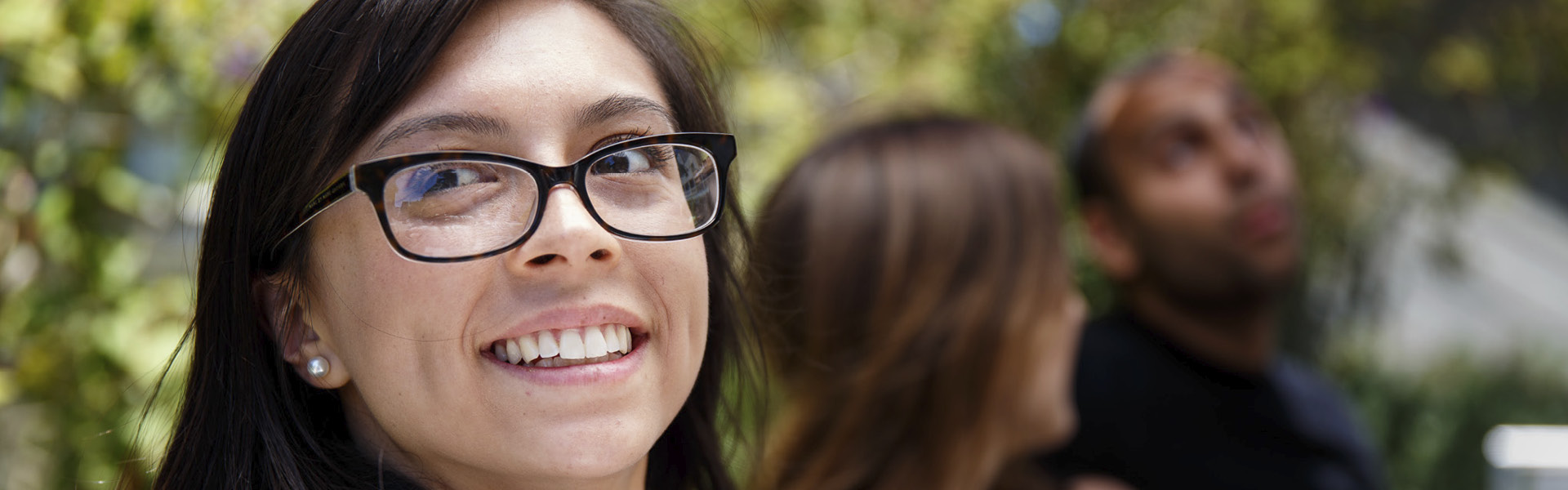 Girl smiling with two people in the background