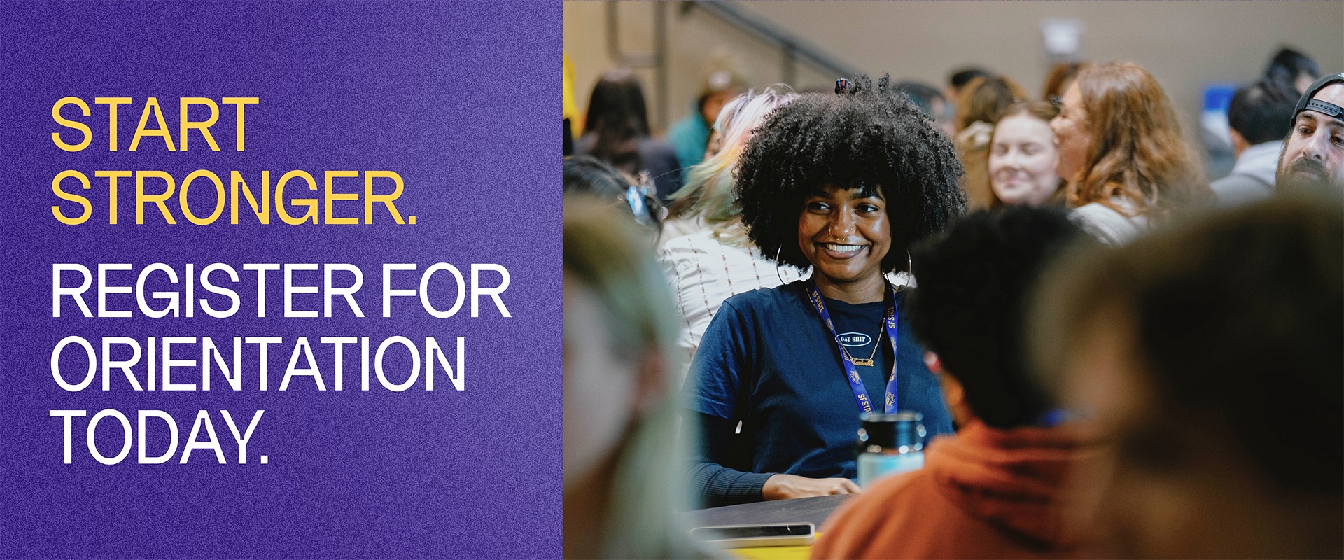 Student smiling in a room of seated students